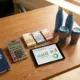 Kantoorbureau met calculator, eurobankbiljetten, tablet met budgetgrafieken en duurzame bedrijfscadeaus zoals waterflessen