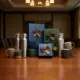 Duurzame relatiegeschenken met waterflessen en koffiemokken in luxe verpakking op houten conferentietafel