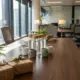 Duurzame waterflessen en koffiemokken op houten vergadertafel met cadeaus en planten in modern kantoor