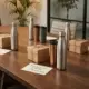 Duurzame bedrijfsgeschenken op houten vergadertafel: thermobekers, waterflessen en eco-vriendelijke geschenkdozen