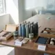 Diverse zakelijke cadeaus georganiseerd op houten vergadertafel met duurzame waterflessen, geschenkdozen en eco-accessoires