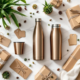 Duurzame relatiegeschenken met RVS waterflessen en koffiemokken op marmeren ondergrond met bamboe accessoires