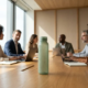 Bio-gebaseerde waterfles met bamboevezel textuur op conferentietafel tijdens zakelijke teamvergadering met professionals