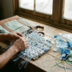 Handen van een arbeider die gerecyclede plastic flessen tot isolatiemateriaal voor een eco-koeltas verwerkt op houten werkbank