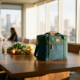 Luxe eco-vriendelijke koeltas van gerecycled oceaanplastic op houten vergadertafel met biologische producten en herbruikbare waterfles