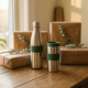 Roestvrijstalen herbruikbare waterfles en thermobeker op eiken bureau met duurzame kraftpapieren cadeaudozen en groen plantje.
