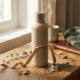 Roestvrijstalen herbruikbare waterfles met kraftpapieren lint op eiken bureau, omringd door droge eucalyptustakjes in warm natuurlijk licht.