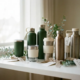 Roestvrijstalen herbruikbare waterflessen en geïsoleerde koffietumblers als personeelsgeschenken op wit bureau, met eucalyptustakjes.